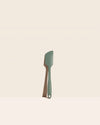 The GIR Sage Green Ultimate Spatula on a pink background.